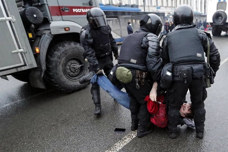 Un hombre que se resistió a ser arrestado es cargado por oficiales en Rusia.