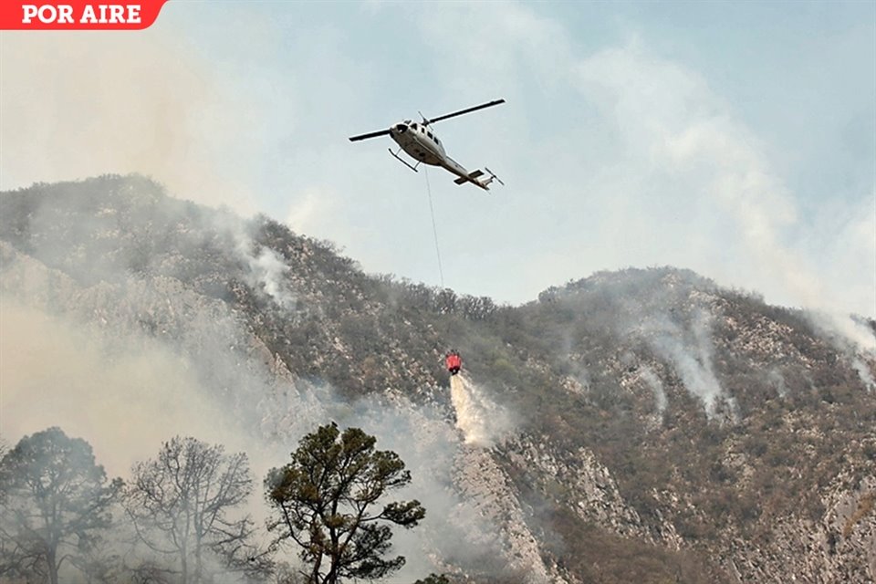 Un helicóptero con un helibalde combate el fuego en una cañada de la Sierra, en los límites de Montemorelos y Rayones.