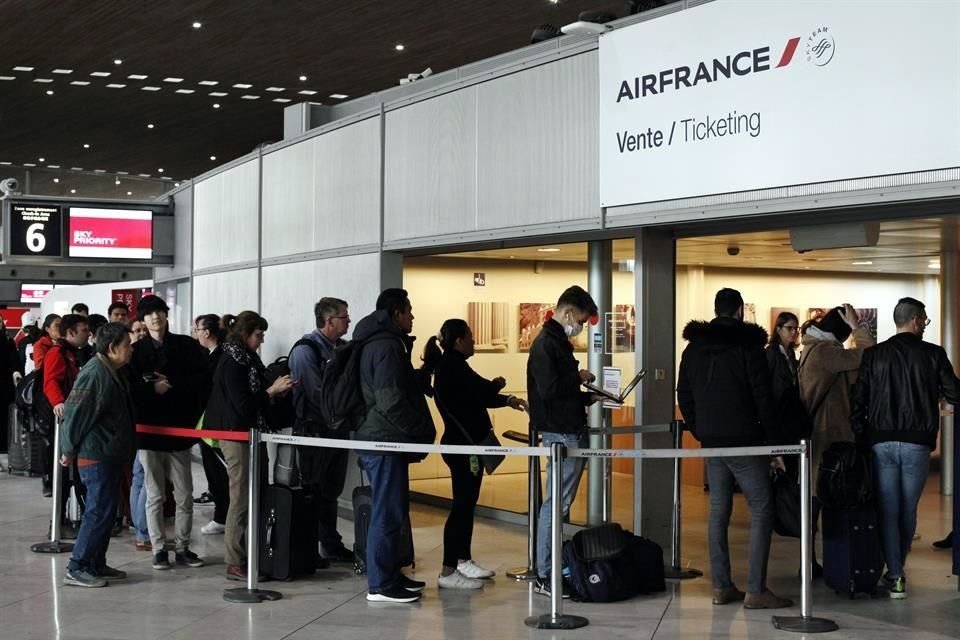 Personas hacen fila en un aeropuerto en París.