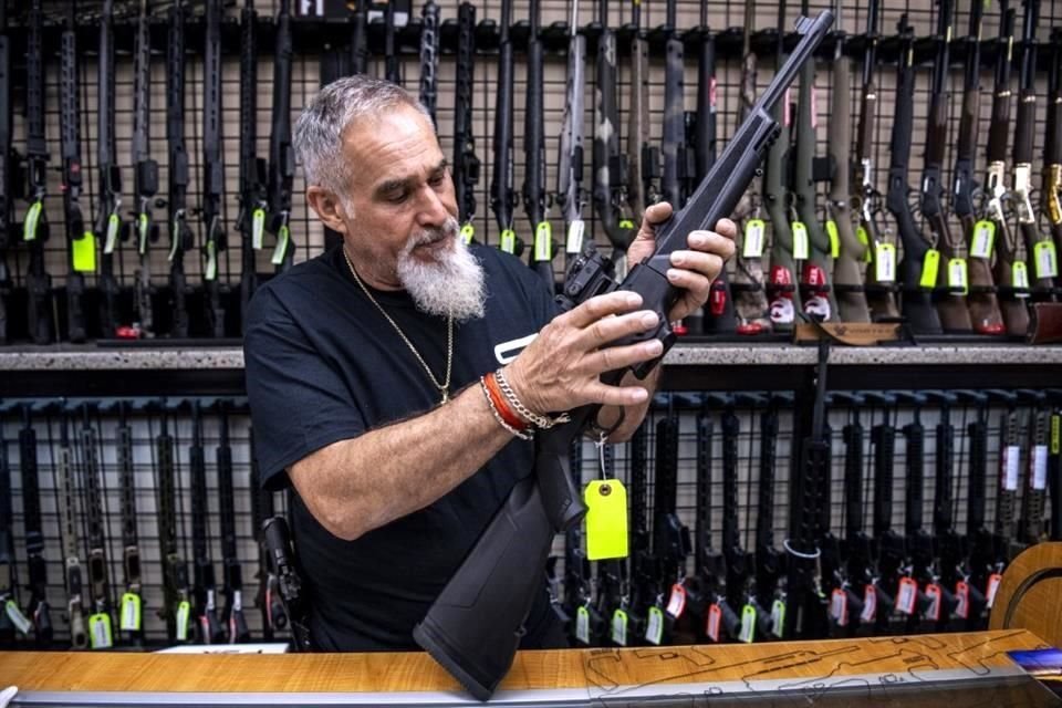 El vendedor John Licata muestra un arma en su tienda en Hempstead, Nueva York.