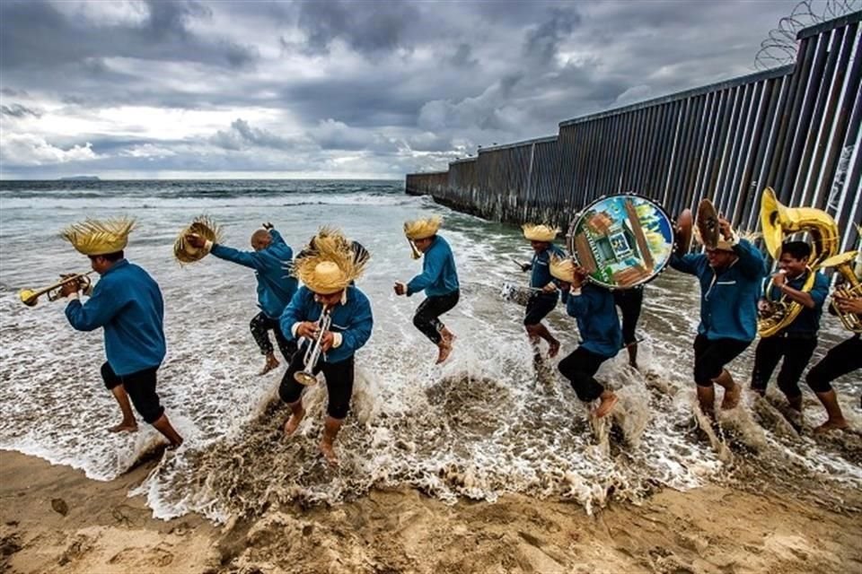 Otra fotografía ganadora es la de José María Cárdenas Camacho, donde en plena frontera oceánica entre México y Estados Unidos, músicos de Oaxaca rompen las olas del mar.