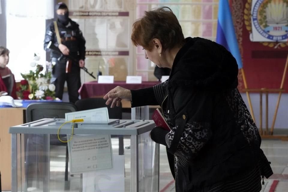 Una mujer deposita su boleta en una casilla de Lugansk, regin ucraniana ocupada por Rusia.