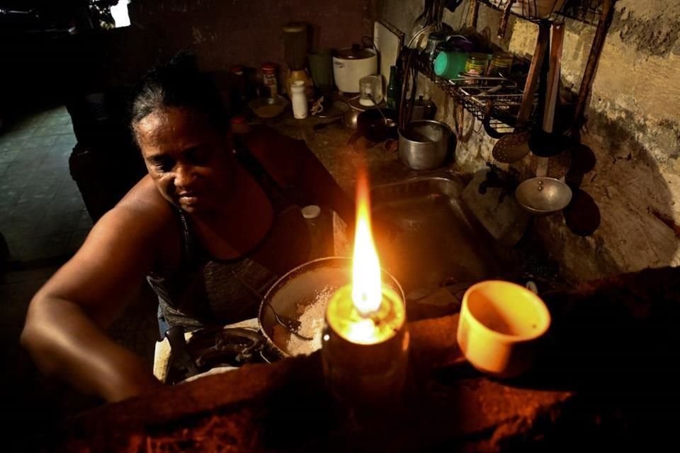 Una mujer cocina sin luz en su casa en La Habana.