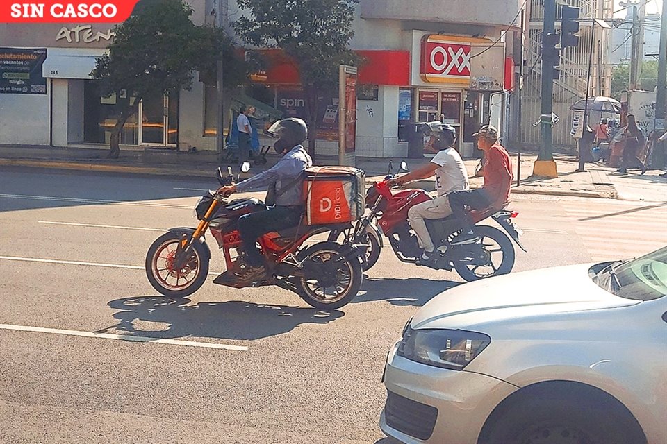 Al circular por Cuauhtémoc, un motociclista traslada a un pasajero que no porta casco.