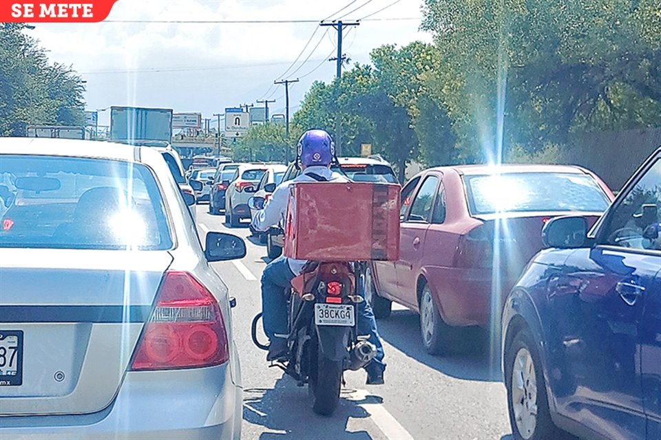 En Churubusco, un hombre avanza en su moto entre los vehículos.