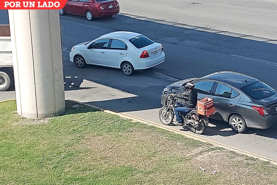 A punto de llegar a una vuelta, un motociclista invade el carril de un vehículo en Avenida Universidad.