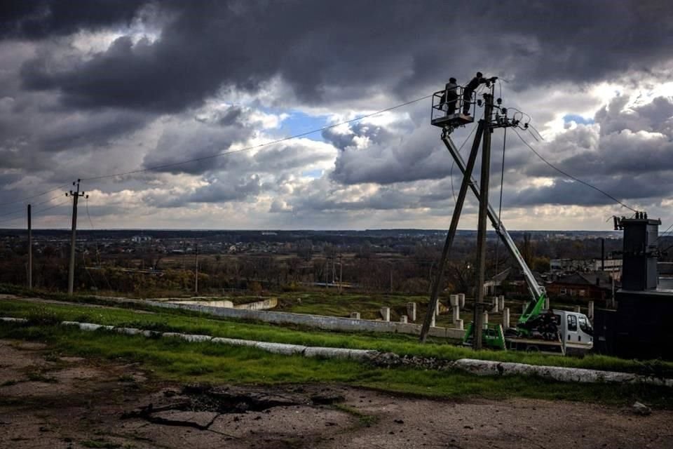 Trabajadores comunitarios reparan líneas eléctricas en la región de Járkov.