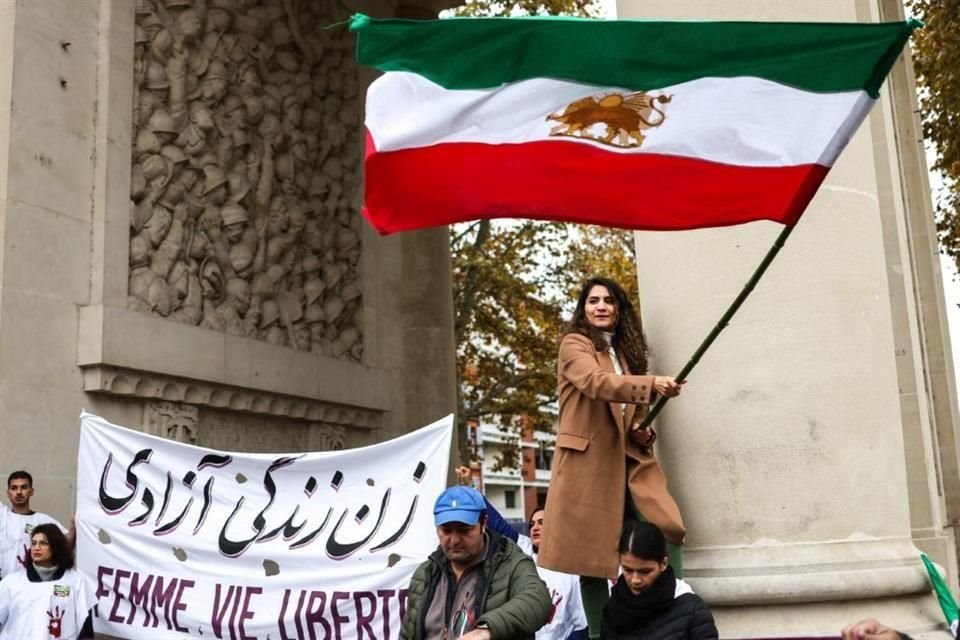 Una mujer ondea la bandera iraní durante una manifestación en apoyo de las manifestaciones en Irán.