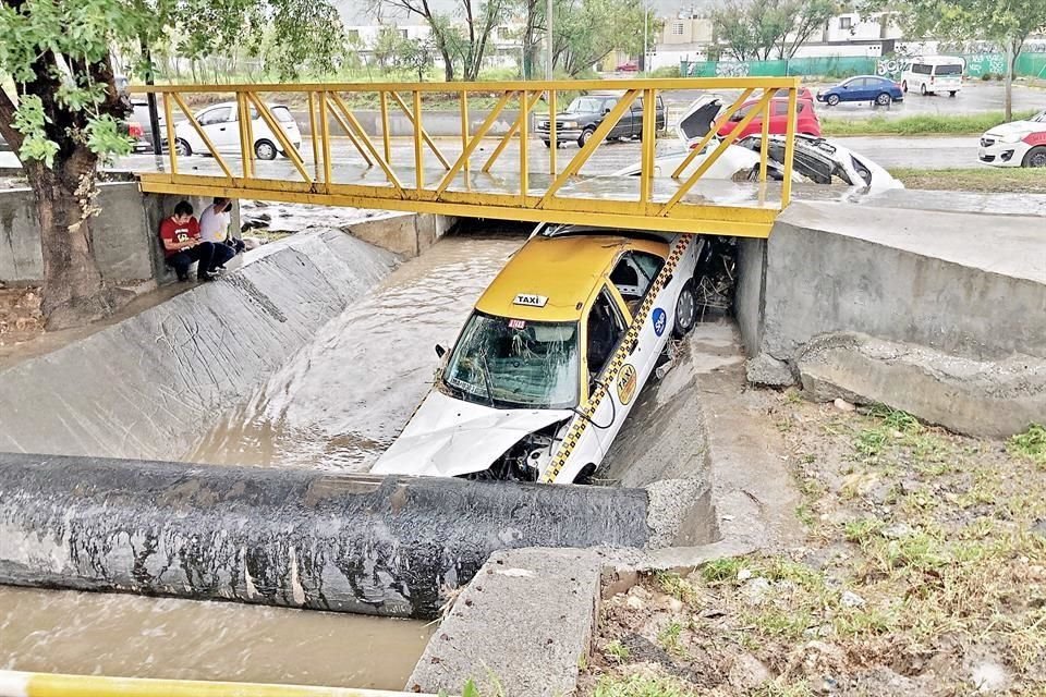 z Varios vehículos fueron arrastrados por la corriente, en la Avenida Raúl Salinas, en Escobedo.