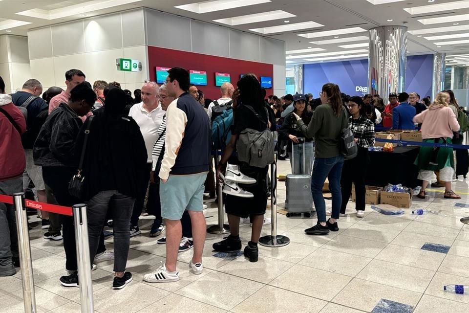 Personas varadas en el aeropuerto de Dubai hacen fila en el mostrador de Emirates.