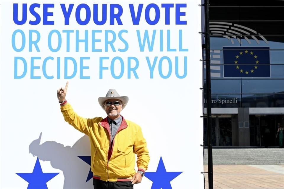 Un hombre posa frente a un cartel afuera del Parlamento Europeo, en Bruselas.