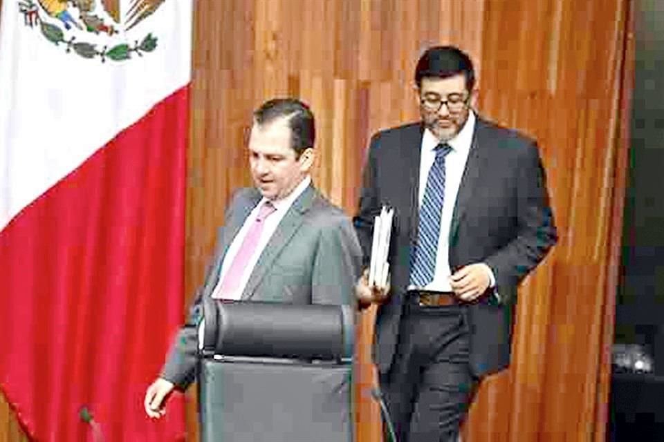 El Magistrado Reyes Rodríguez camina detrás de José Luis Vargas en esta fotografía.