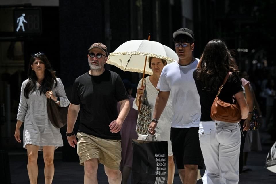 Personas caminan en Manhattan bajo el calor, el 24 de junio del 2025.
