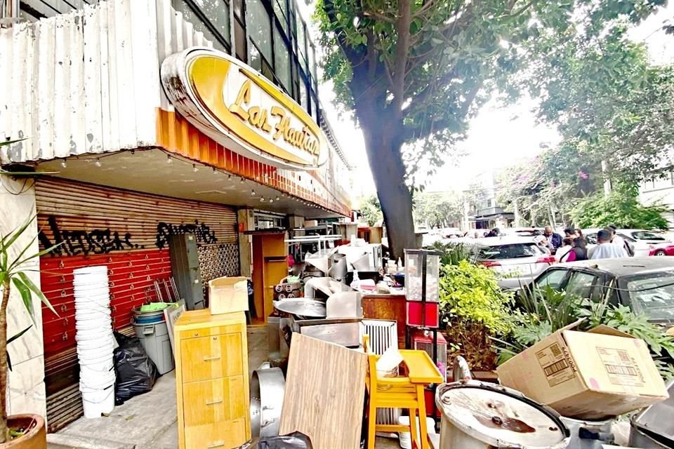 Parrillas, botes y utensilios de cocina fueron apilados en la banqueta ante la mirada de los vecinos y trabajadores.